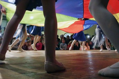 Tanzende Menschen mit Publikum im Hintergrund