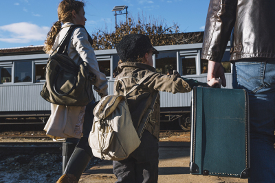 Familie mit Koffern am Bahnhof