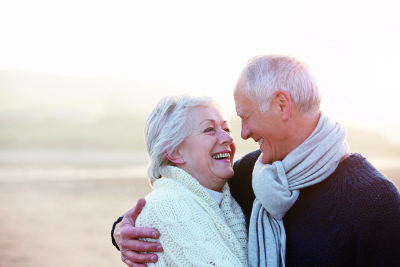 Senior und Seniorin, die sich anlachen und umarmen