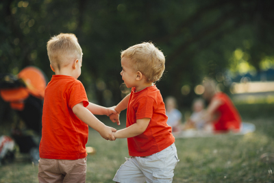 Kinder die Hände halten und draußen spielen