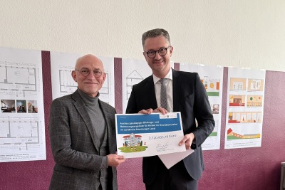 Minister Christian Tischner überreicht den Zuwendungsbescheid an Landrat Uwe Melzer.