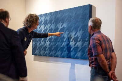 Führung durch die Ausstellung, drei Personen im Dialoa über die Kunstwerke