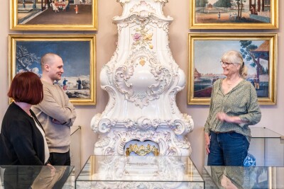 Eine Person führt zwei Personen durch das Schlossmuseum