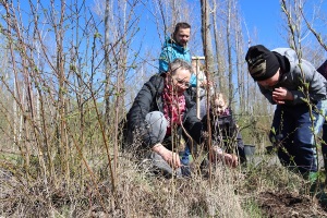 Bürgermeisterin von Lucka Kathrin Backmann-Eichhorn pflanzt zusammen mit einem Hortkind einen Baum.